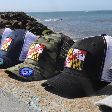 Two women wearing caps by the water