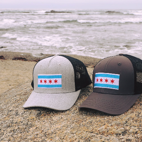 Two women wearing caps by the water